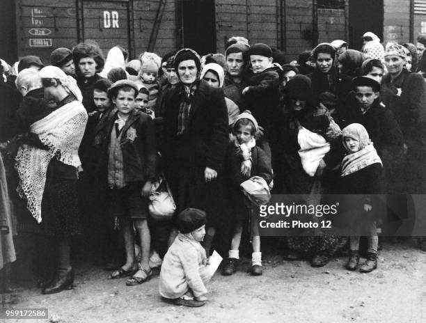 Jewish people in front of a train for deportation to a concentration camp.