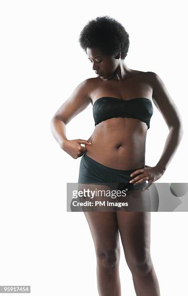 woman pinching her waist - body photos et images de collection
