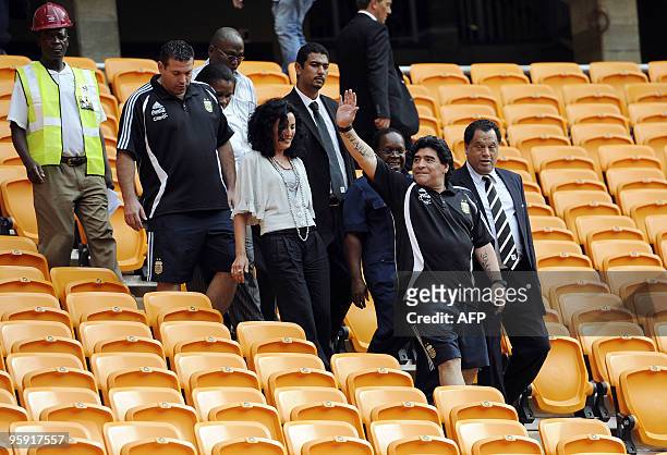 Argentinian soccer head coach Diego Maradona , flanked by 2010 Organising Committee CEO Danny Jordaan , greets workers at Soccer City Stadium on...