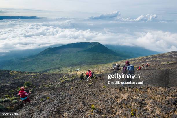 欧米の観光客がニイラゴンゴ火山、コンゴから降順 - ゴマ市 ストックフォトと画像
