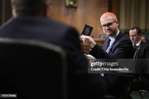 Former director of research for Cambridge Analytica Christopher Wylie pulls out his Canadian passport before testifying to the Senate Judiciary...