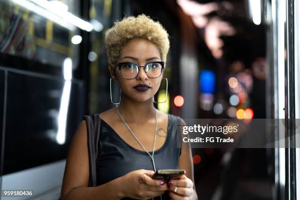 businesswoman using mobile with city on background - young adult mobile phone serious stock pictures, royalty-free photos & images