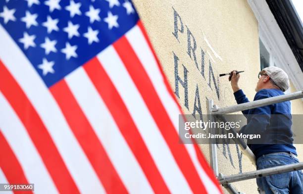 Painter painting the words Prince Harry on the wall of the Prince Harry pub near the castle on May 16, 2018 in Windsor, England. Preparations...