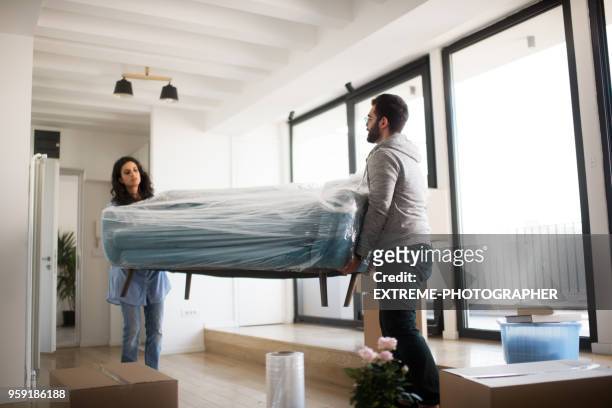 couple in their new apartment - new sofa stock pictures, royalty-free photos & images