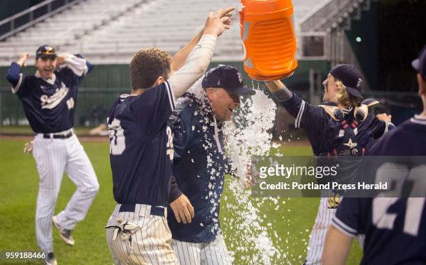 Portland players dump the gatorade bucket on their head coach Mike Rutherford's head after their 11-1 win against Deering. The game was Rutherford's...