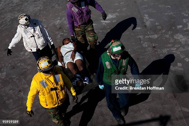 Haitian earthquake victim is carried on the flight deck after arriving by helicopter on board the USNS Comfort, a U.S. Naval hospital ship, on...