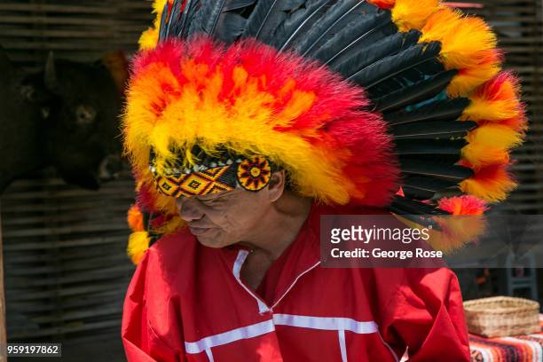 Native American in full head dress poses for pictures along the highway on May 11, 2018 in Cherokee, North Carolina. Located near the entrance to...