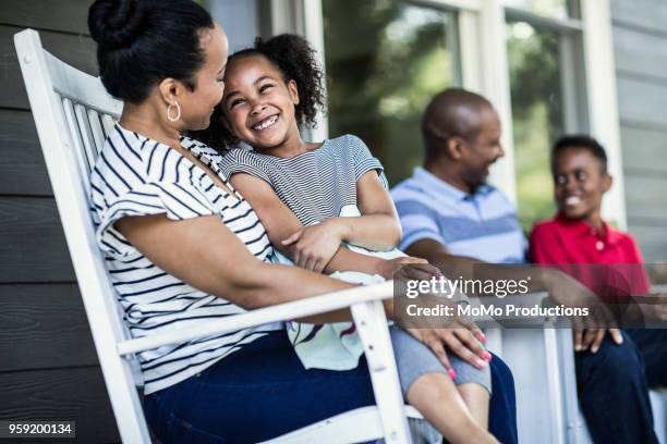 family laughing on front porch - american way of life stock pictures, royalty-free photos & images