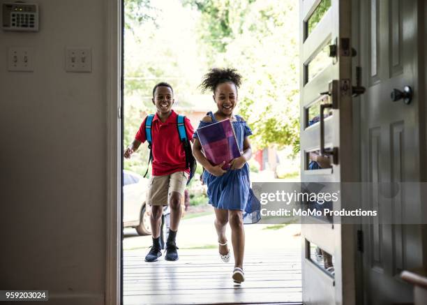 children running into home after school - liberty shoes stock pictures, royalty-free photos & images