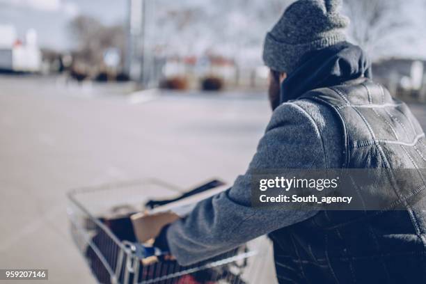 senzatetto che spinge il carrello della spesa - mendicante foto e immagini stock