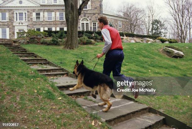 Tennis player Ivan Lendl, a 26 year old Czechoslovakian, runs up the steps on the grounds of his Greenwich, CT mansion, alongside his German Shepherd...