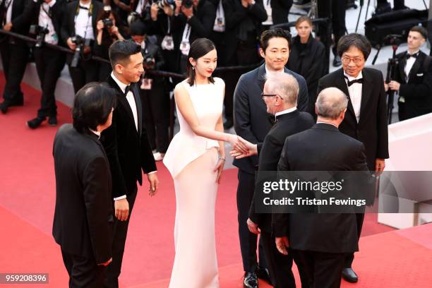 Director Chang-dong Lee, actor Ah-in Yoo, actress Jong-seo Jeon, greeting Cannes Film Festival President Pierre Lescure, actor Steven Yeun greeting...