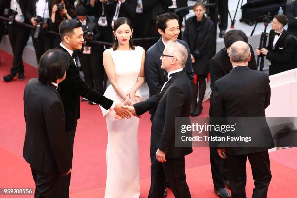 Director Chang-dong Lee, actor Ah-in Yoo greeting Cannes Film Festival Director Thierry Fremaux, actress Jong-seo Jeon, , actor Steven Yeun and...