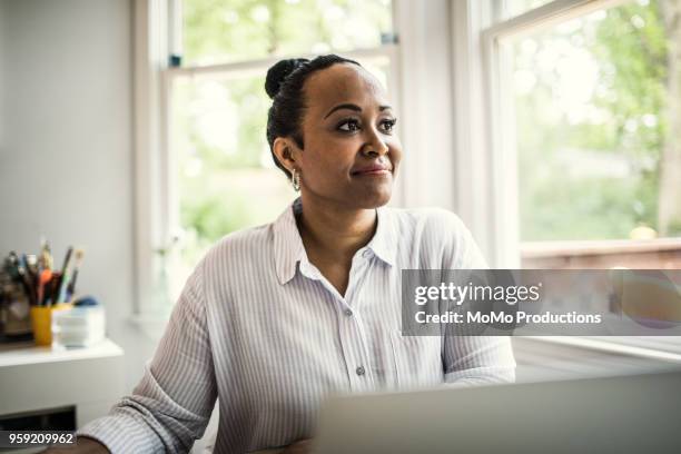 woman working on laptop in kitchen - 僅成年女人 個照片及圖片檔