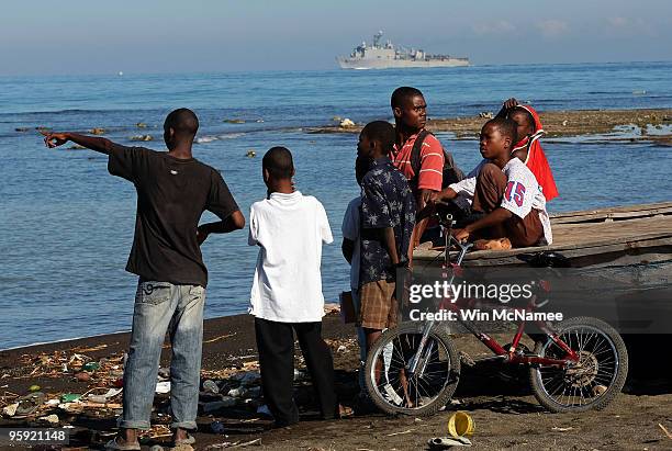 Young Haitian boys watch from the beach as crew members of the Canadian Navy vessel HMCS Athabaskan make their way to shore in the city of Leogane on...