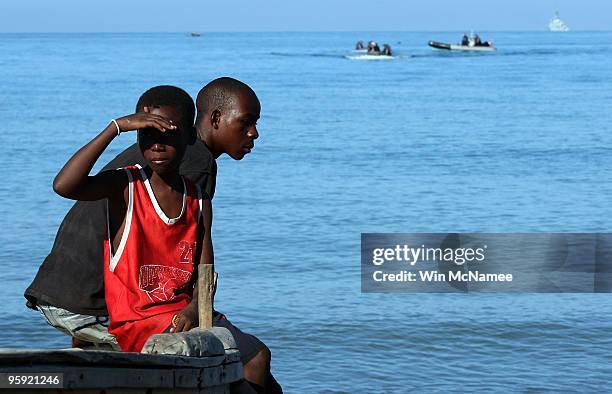 Young Haitian boys watch from the beach as crew members of the Canadian Navy vessel HMCS Athabaskan make their way to shore in the city of Leogane on...