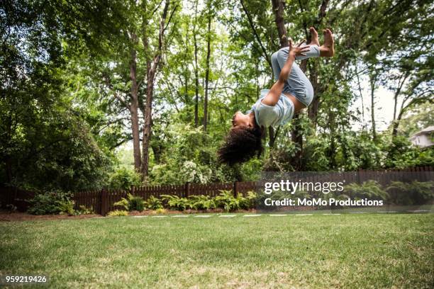 young girl doing backflip outdoors - gymnastic backflip stock pictures, royalty-free photos & images