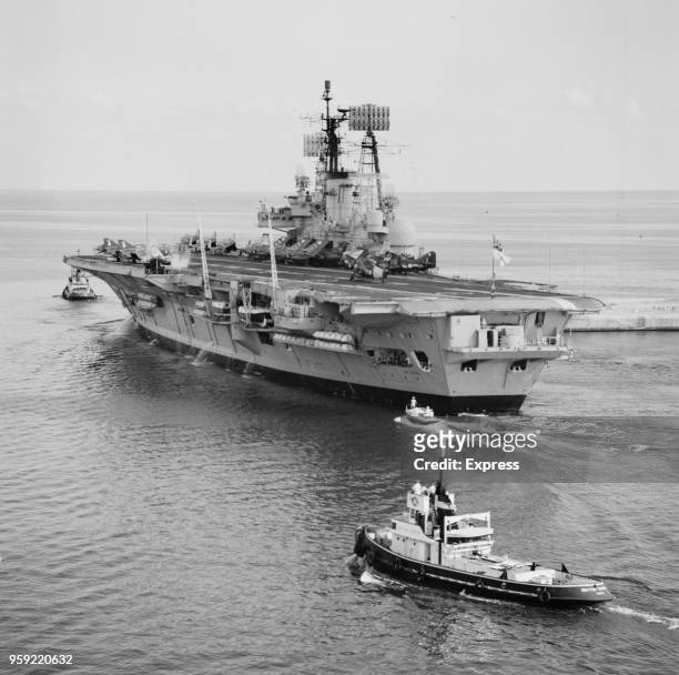 Ark Royal , Audacious-class aircraft carrier of the Royal Navy is escorted by tugs as she leaves Malta Dockyard in the Grand Harbour, Valletta, Malta...