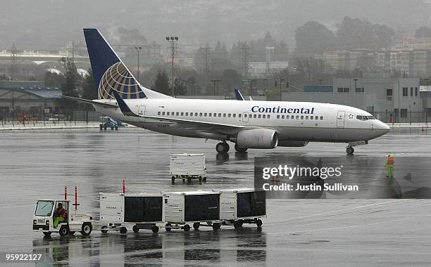 Continental Airlines plane is guided by a worker as it taxis to the terminal at San Francisco International Airport January 21, 2010 in San...