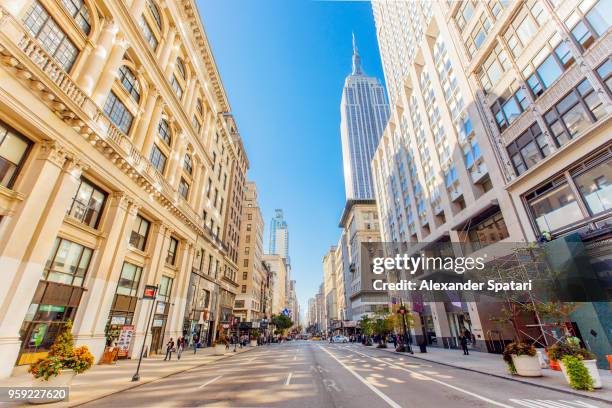 fifth avenue and empire state building in manhattan, new york, usa - nyc building sun ストックフォトと画像