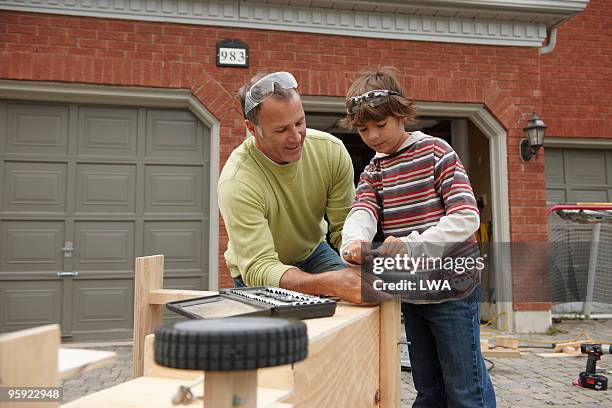 father and son building soap box car - soapbox cart stock pictures, royalty-free photos & images