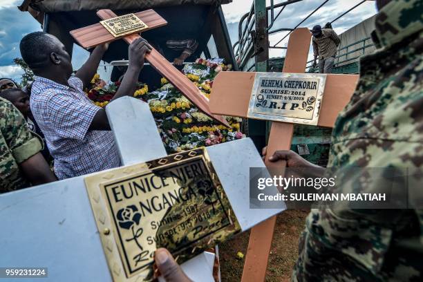 People prepare crosses during a mass burial of the 48 victims that were killed when a dam burst on May 10, after attending their mass memorial...