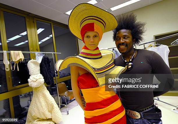 Fashion designer Anggy Haif from Cameroon shares a light moment with a model wearing one of his creation in backstage after a Biodiversity fashion...