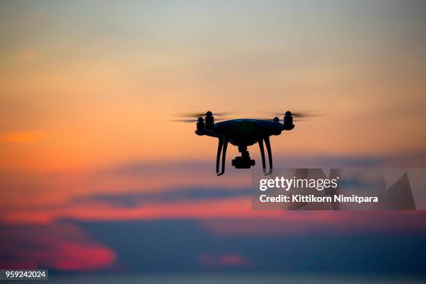 the drone in sunset sky. - flying drone stock-fotos und bilder