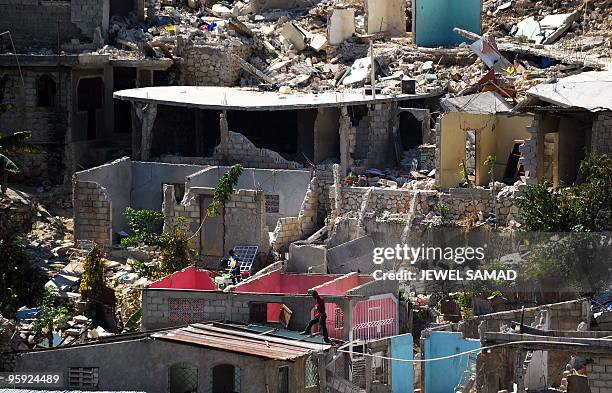 Man fixes the roof of his collapsed house in Port-au-Prince on January 21, 2010 following the massive 7.0-magnitude quake that shattered the country....