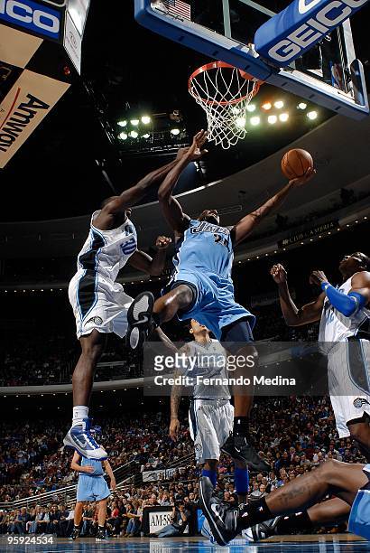 Paul Millsap of the Utah Jazz puts up a shot against Brandon Bass and Dwight Howard of the Orlando Magic during the game on December 21, 2009 at...