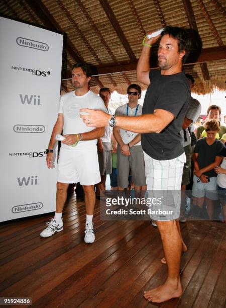 Former tennis players Pat Rafter and Henri Leconte compete in a Wii Sports tennis showdown at Grand Slam Oval during day five of the 2010 Australian...