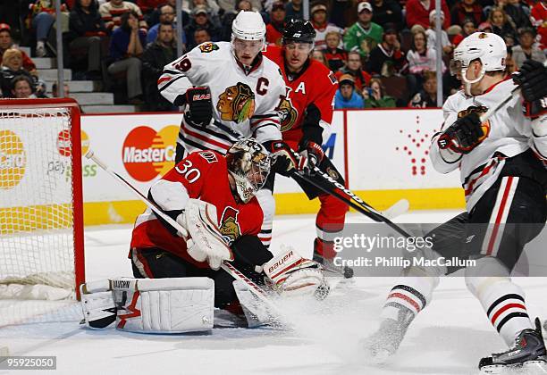 Goalie Brian Elliott of the Ottawa Senators stops the puck against Jonathan Toews and Marian Hossa of the Chicago Blackhawks, at Scotiabank Place on...