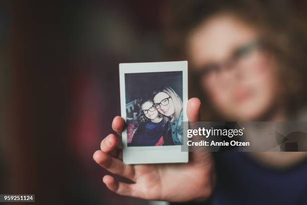 girl holding instant film photo - casual clothing photos stock-fotos und bilder