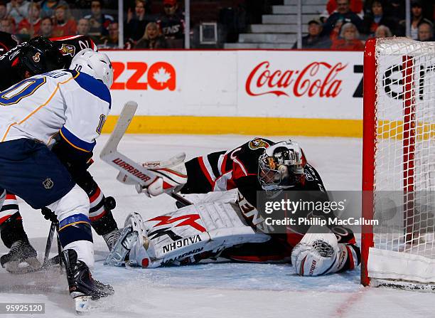 Brian Elliott of the Ottawa Senators makes a save while teammate Mike Fisher tries battle for the rebound with Andy McDonald of the St. Louis Blues...