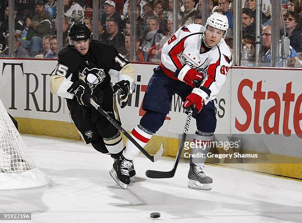 Tyler Sloan of the Washington Capitals moves the puck in front of Dustin Jeffrey of the Pittsburgh Penguins on January 21, 2010 at Mellon Arena in...