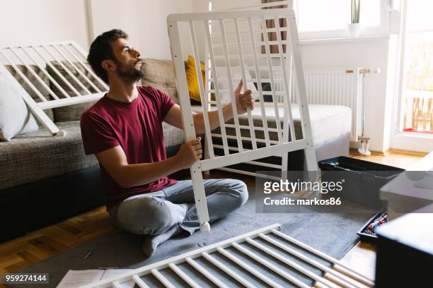preparing the crib for new family member - cot stock pictures, royalty-free photos & images