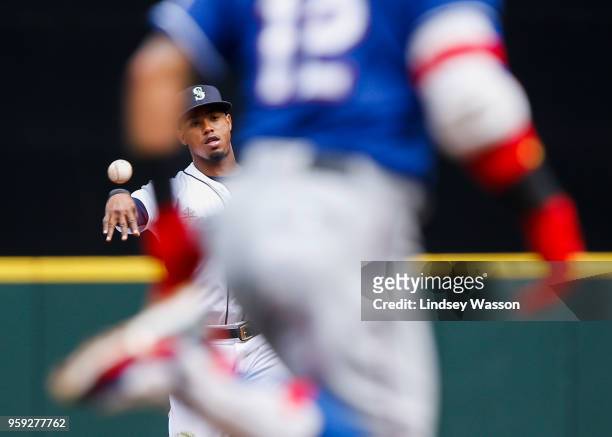 Jean Segura of the Seattle Mariners throws out Rougned Odor of the Texas Rangers at first base in the third inning at Safeco Field on May 16, 2018 in...