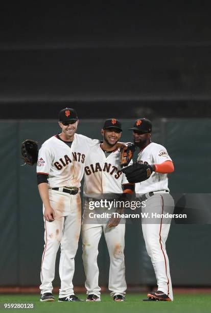 Austin Slater, Gregor Blanco and Andrew McCutchen of the San Francisco Giants celebrates defeating the Cincinnati Reds 10-7 at AT&T Park on May 14,...