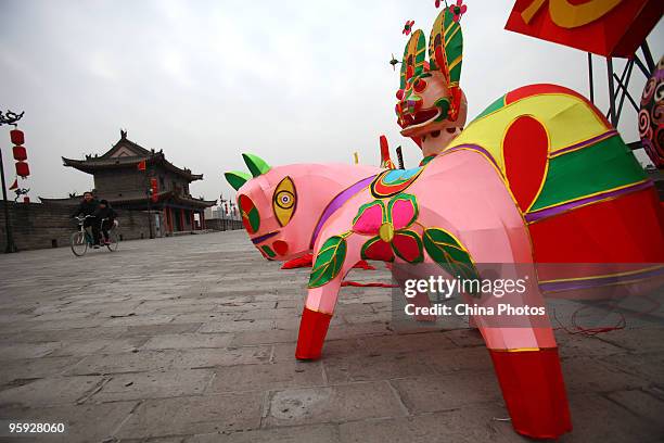 People ride a bike past light decorations installed for the upcoming Chinese new year at the South Gate of Xian City Wall on January 21, 2010 in Xian...