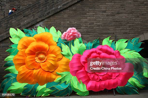 Tourist walks past light decorations installed for the upcoming Chinese new year at the South Gate of Xian City Wall on January 21, 2010 in Xian of...