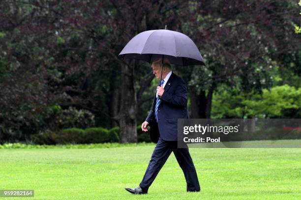 President Donald Trump walks towards Marine One while departing the White House to visit first lady Melania Trump at Walter Reed National Military...