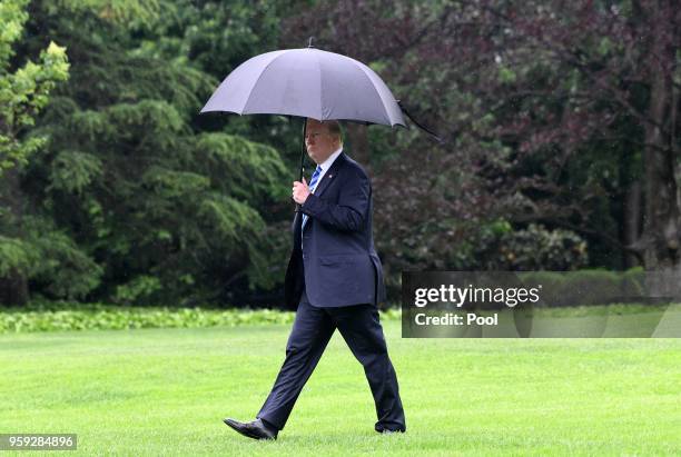 President Donald Trump walks towards Marine One while departing the White House to visit first lady Melania Trump at Walter Reed National Military...