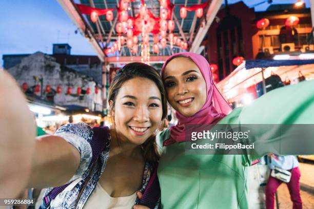 dos amigos teniendo selfie juntos en el mercado - malásia fotografías e imágenes de stock
