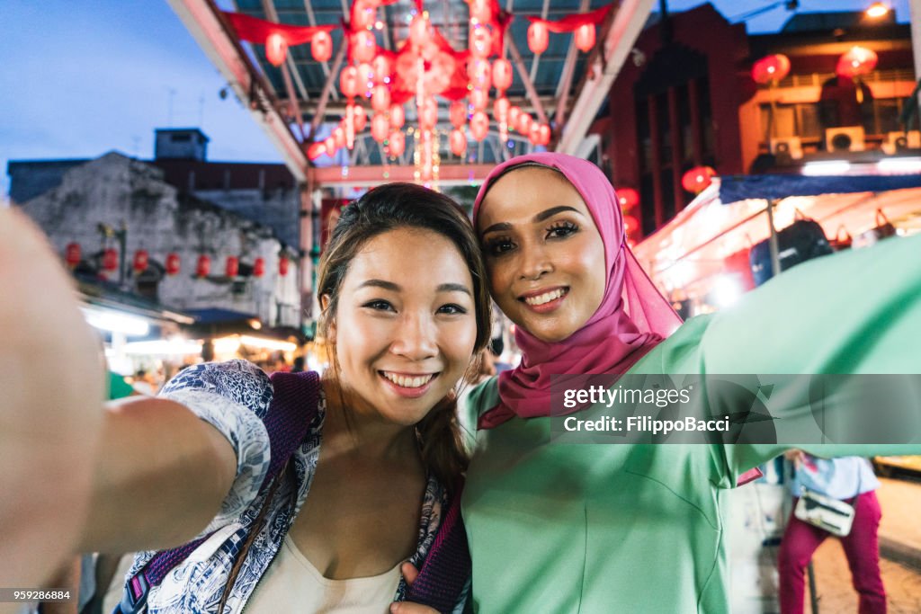 Two friends having selfie together at the market