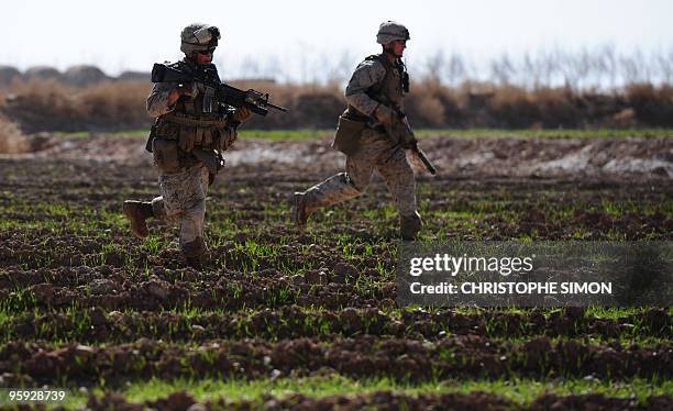 Marines from the first Battalion, 6th regiment run for cover after hearing bullets whizzing during a patrol in the outskirts of Marjah in central...