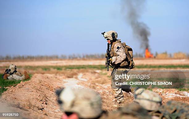 Marines from the first Battalion, 6th regiment run for cover after hearing bullets whizzing during a patrol in the outskirts of Marjah in central...