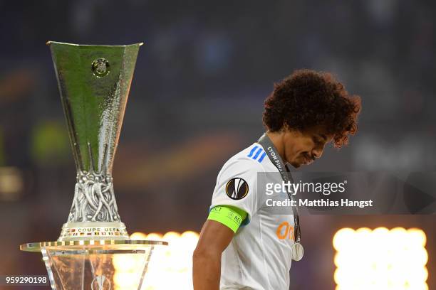 Luiz Gustavo of Marseille walks past the trophy after collecting his runners up medal following the UEFA Europa League Final between Olympique de...