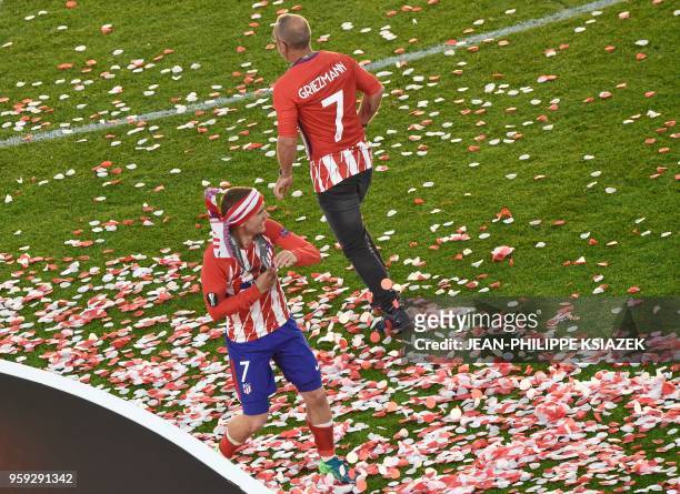 Atletico Madrid's French forward Antoine Griezmann celebrates their victory past his father Alain Griezmann after winning the UEFA Europa League...
