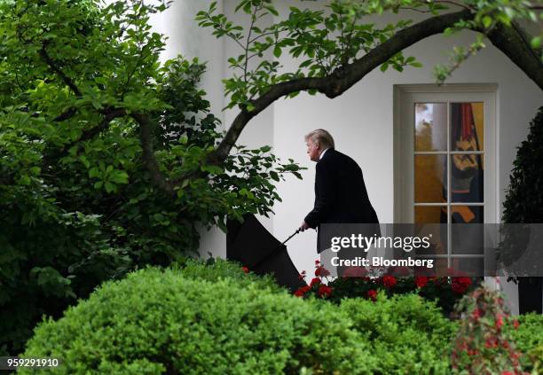 President Donald Trump carries an umbrella while leaving the White House in Washington, D.C., U.S., on Wednesday, May 16, 2018. Trump continued to...