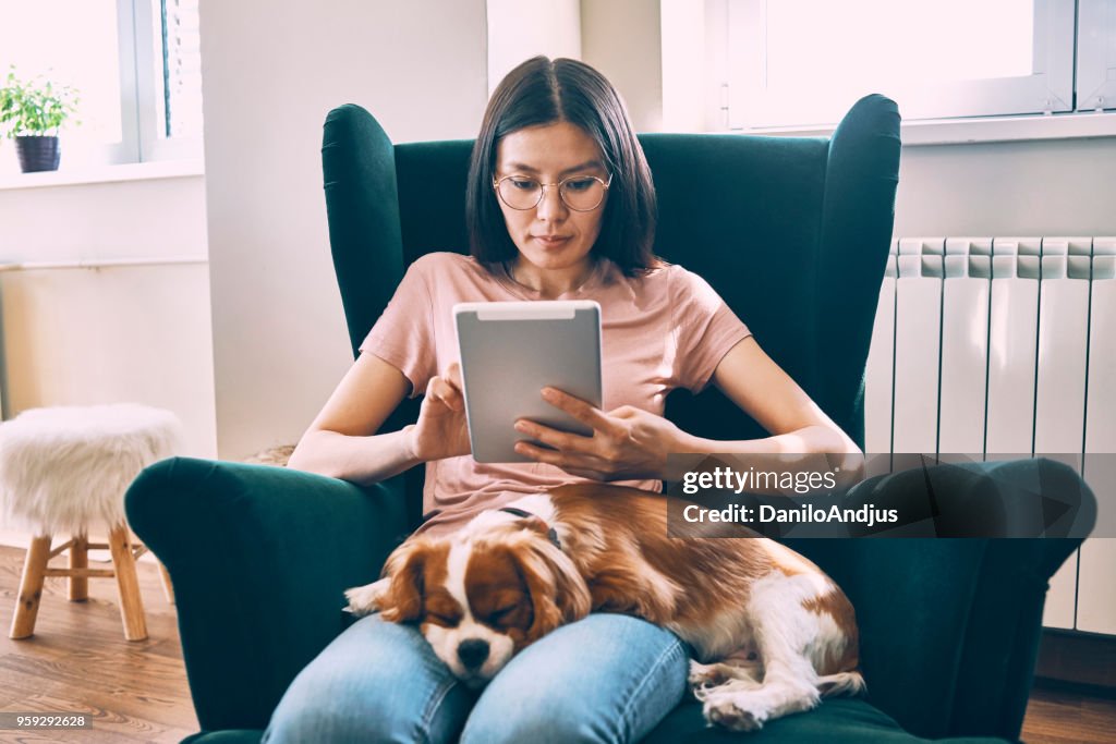 Giovane donna rilassante a casa con il suo tablet